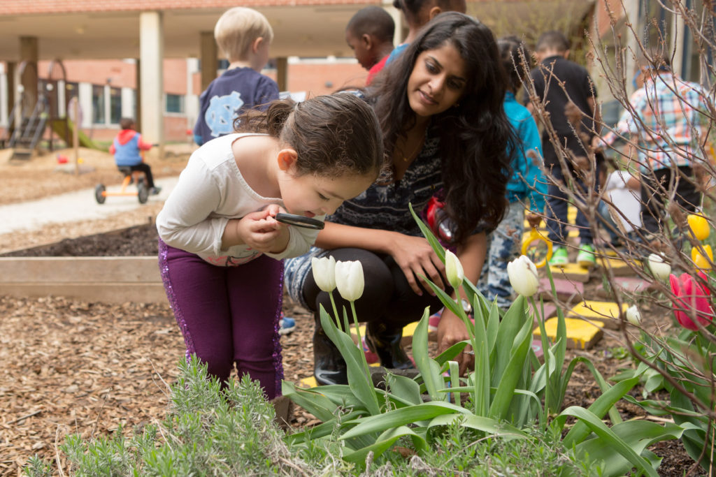 Preschool girl and teacher in garden